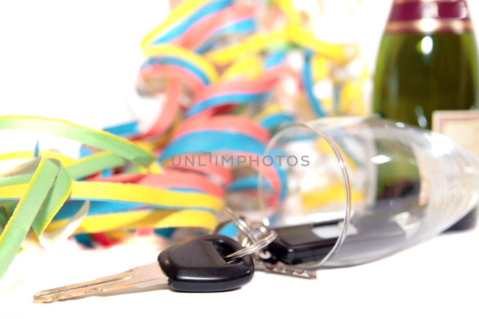 champagne with keys inside fallen glass flute on white background depicting drunk driving and addictions can kill