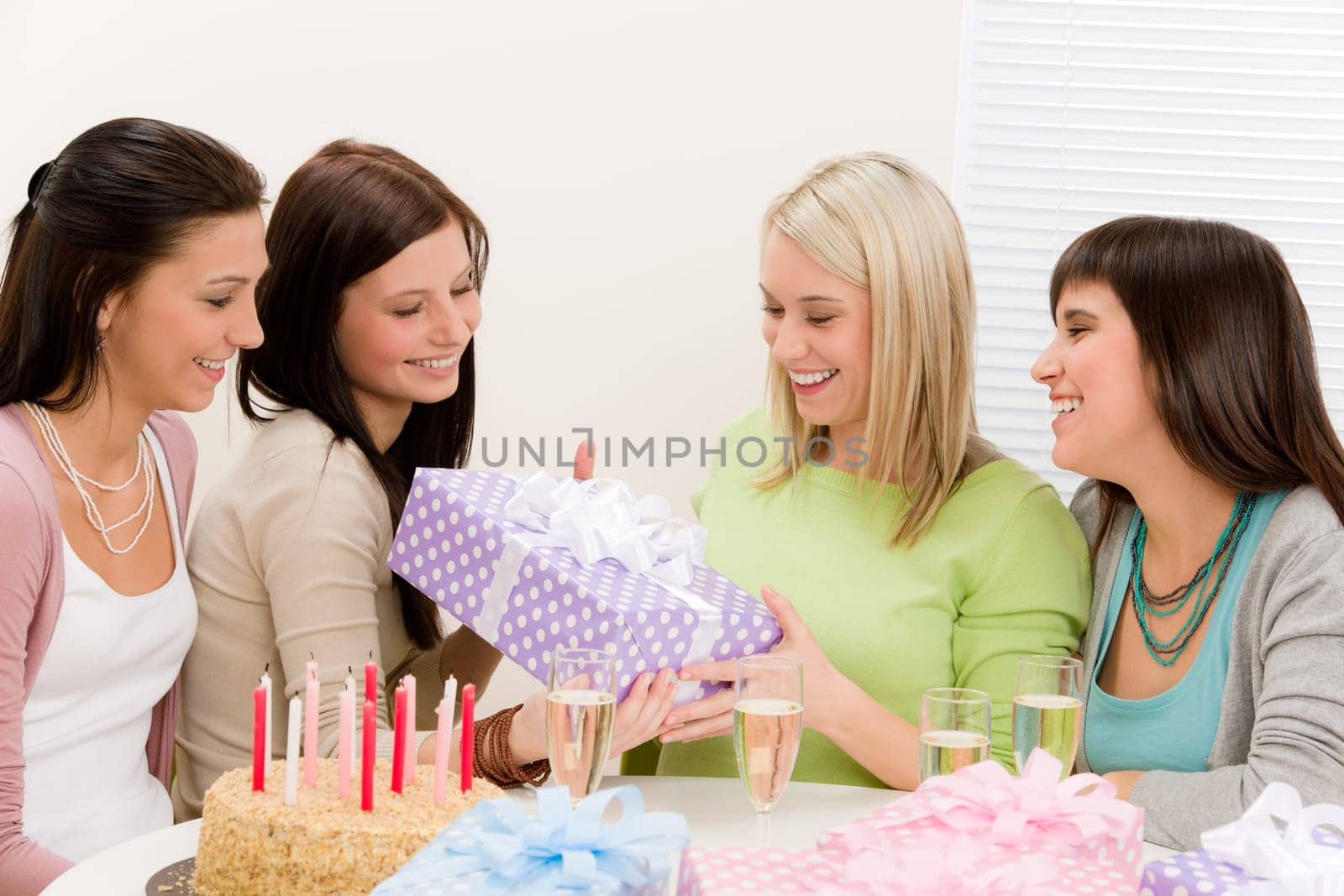 Birthday party - happy woman getting present, champagne, cake