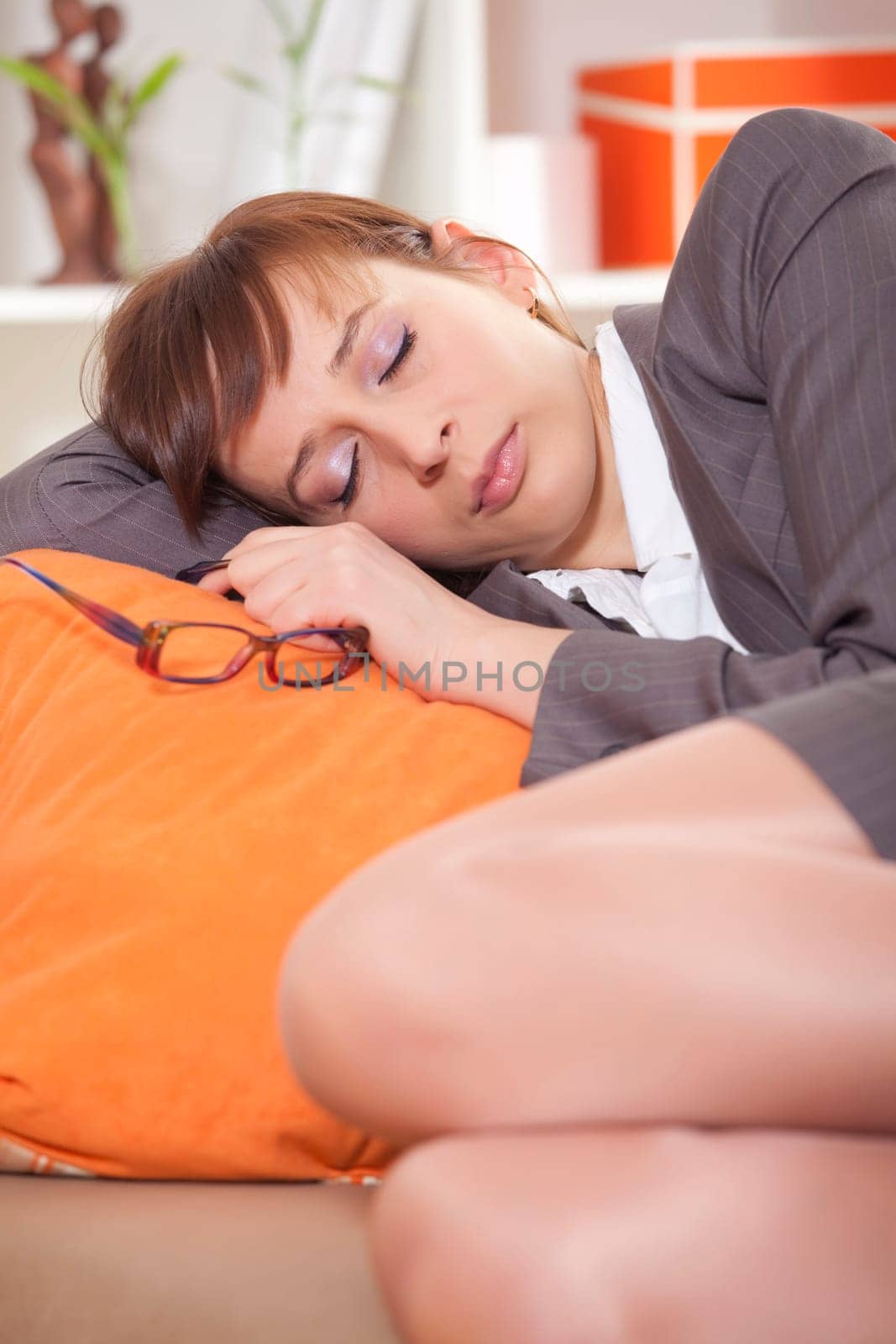 tired woman in business suit sleeping on the couch