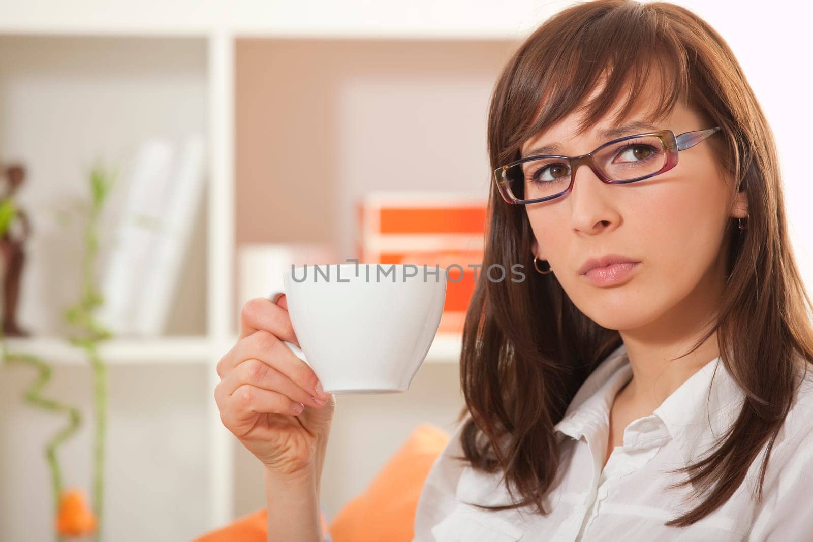 woman in business shirt with cup coffee in her apartment