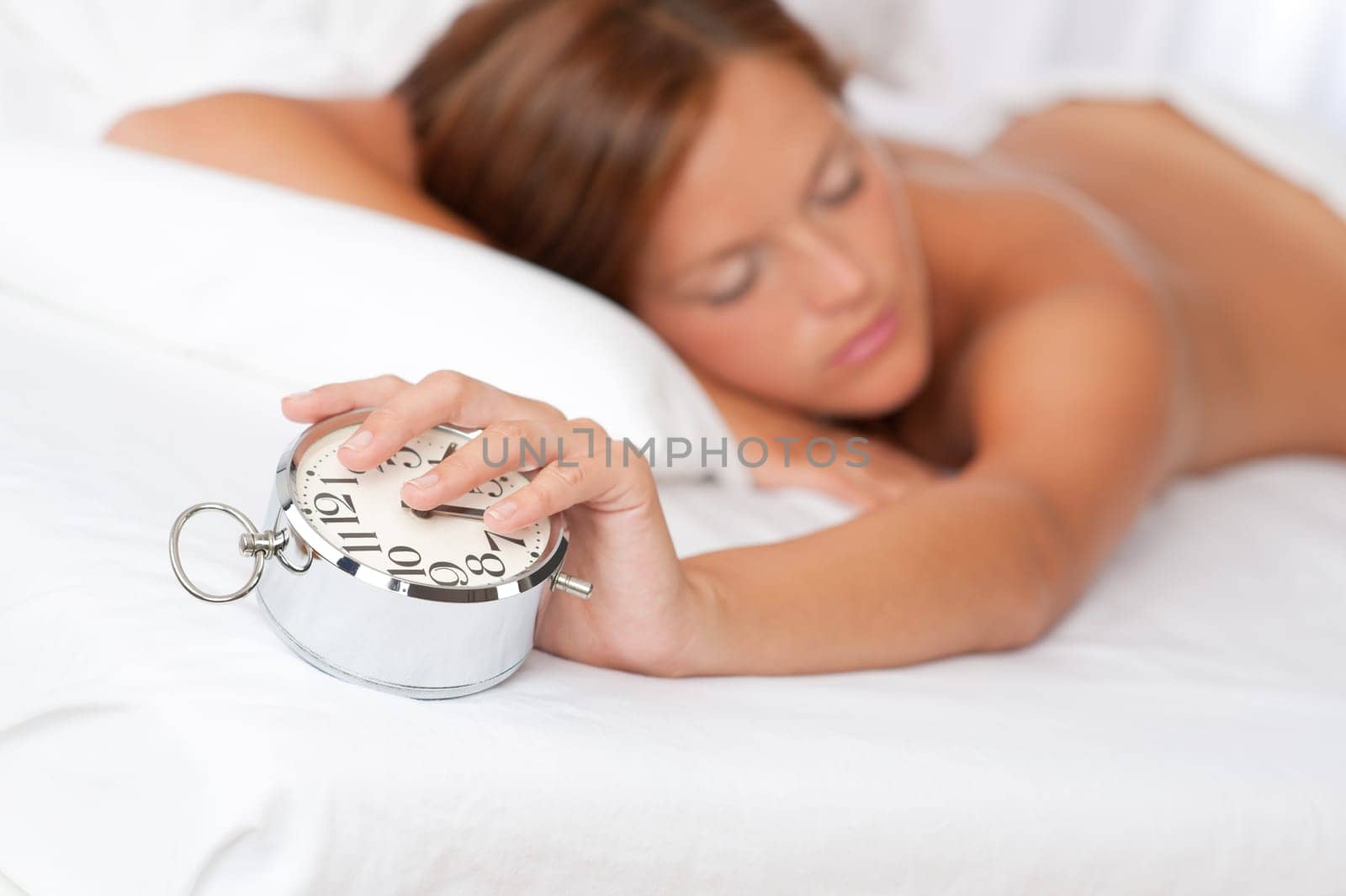 Woman holding alarm clock and sleeping