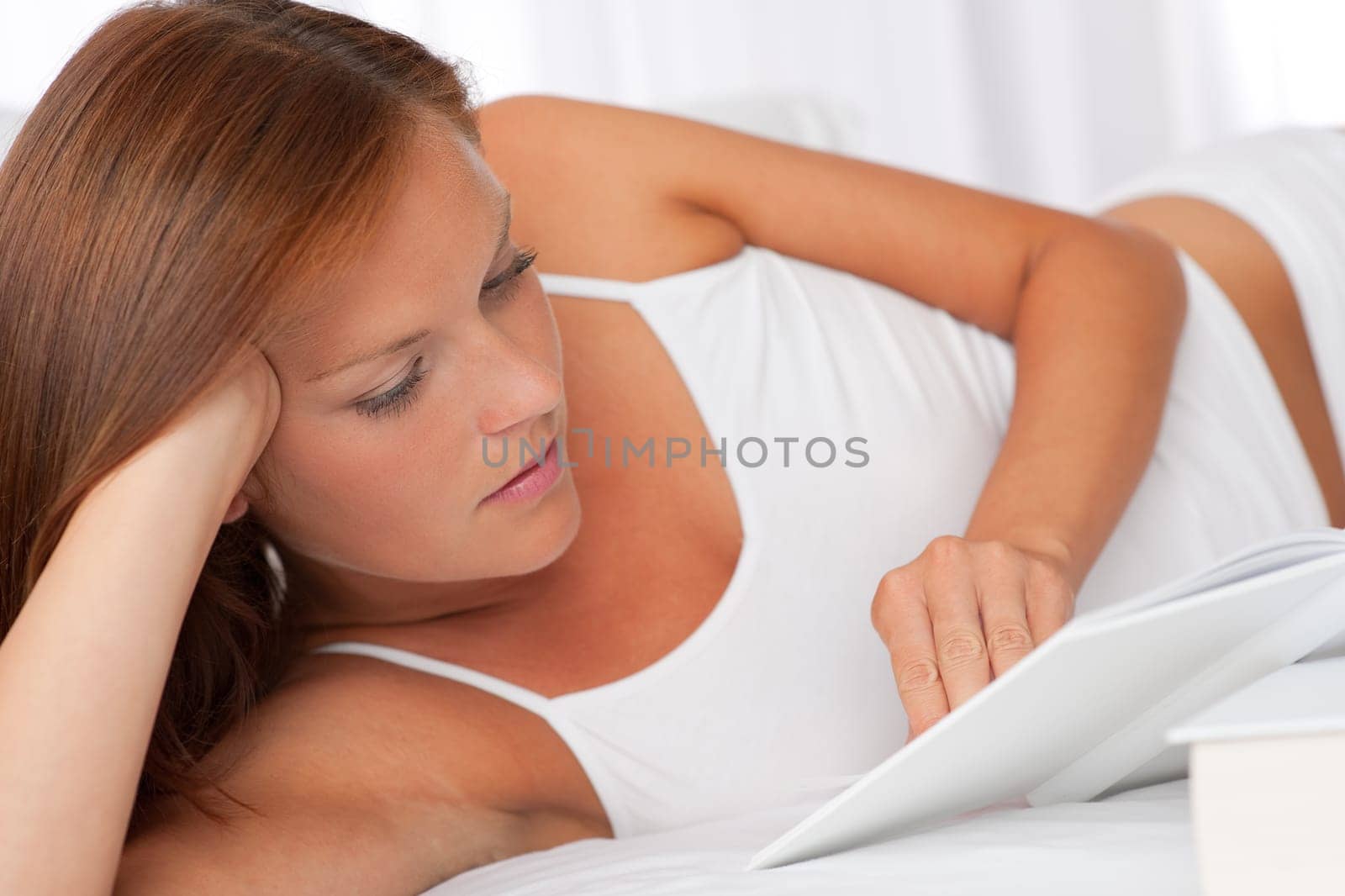 Young woman reading white book, shallow DOF