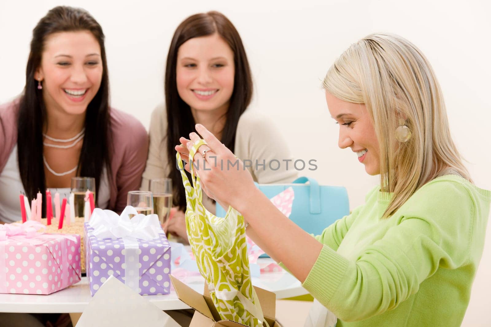Birthday party - woman unwrap present, celebrating with champagne and cake