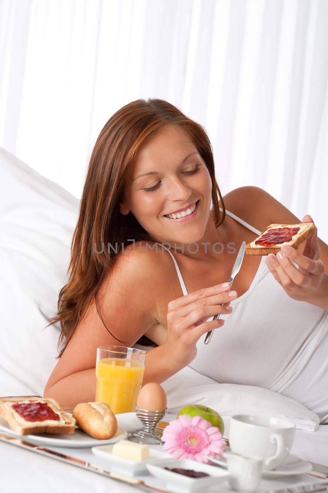 Young woman having breakfast in luxury hotel room