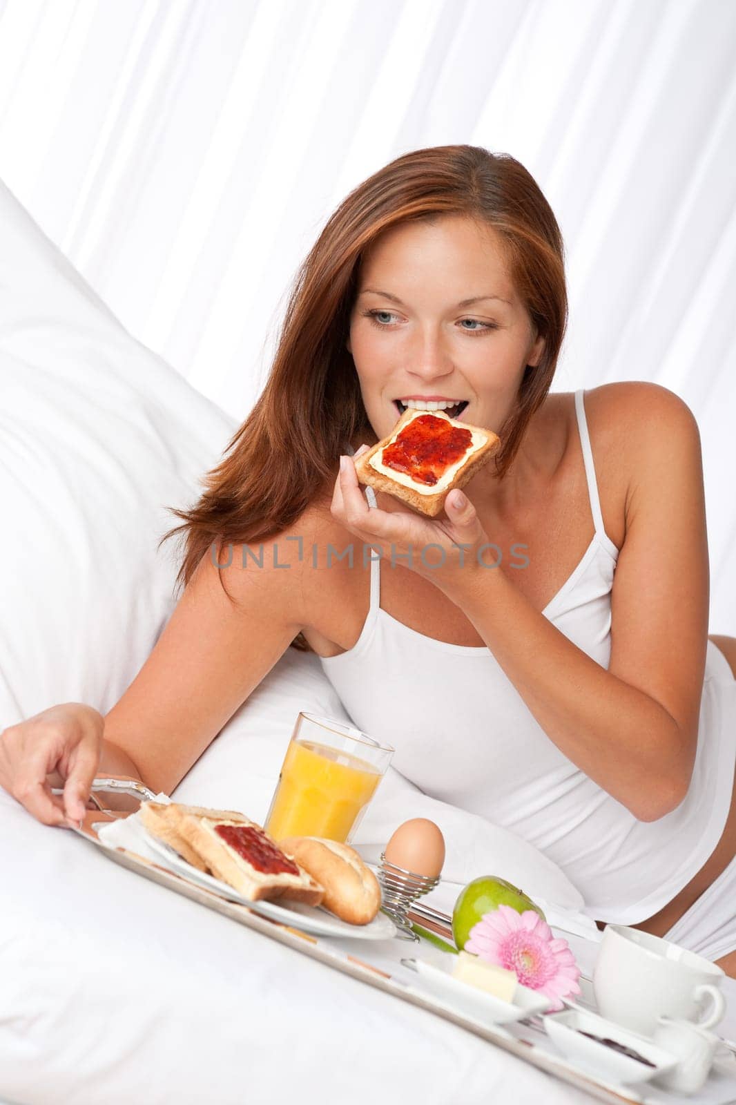 Young woman having breakfast in luxury hotel room