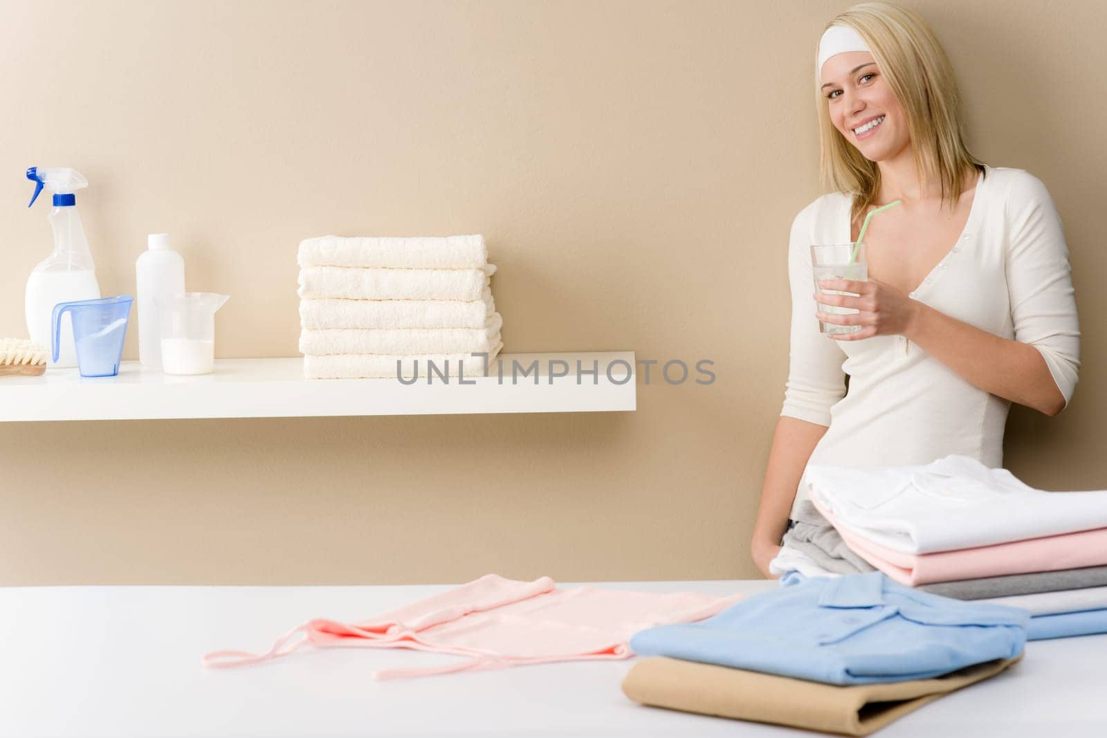 Laundry ironing - woman break with drink after housework