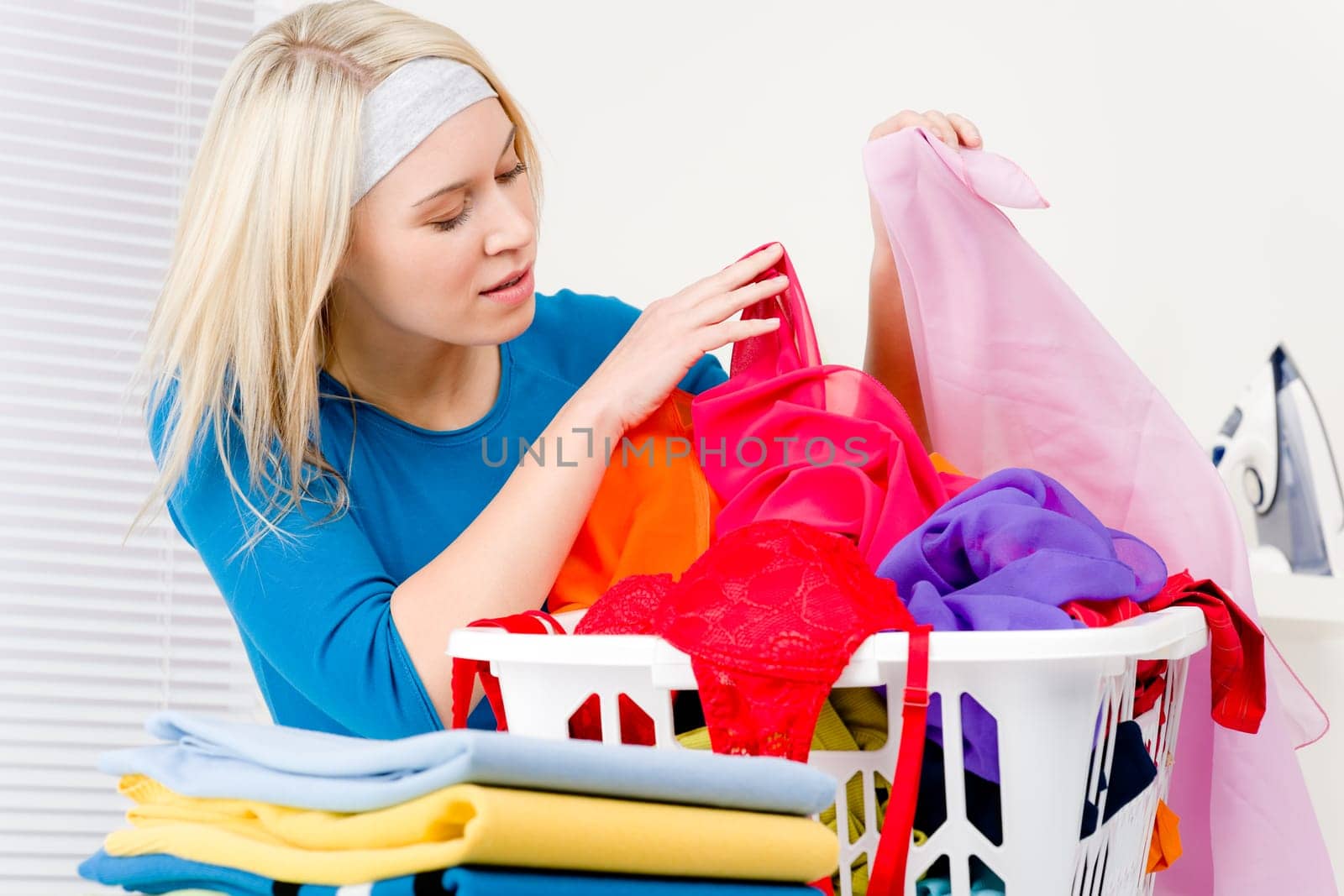 Laundry - woman folding clothes home, housework