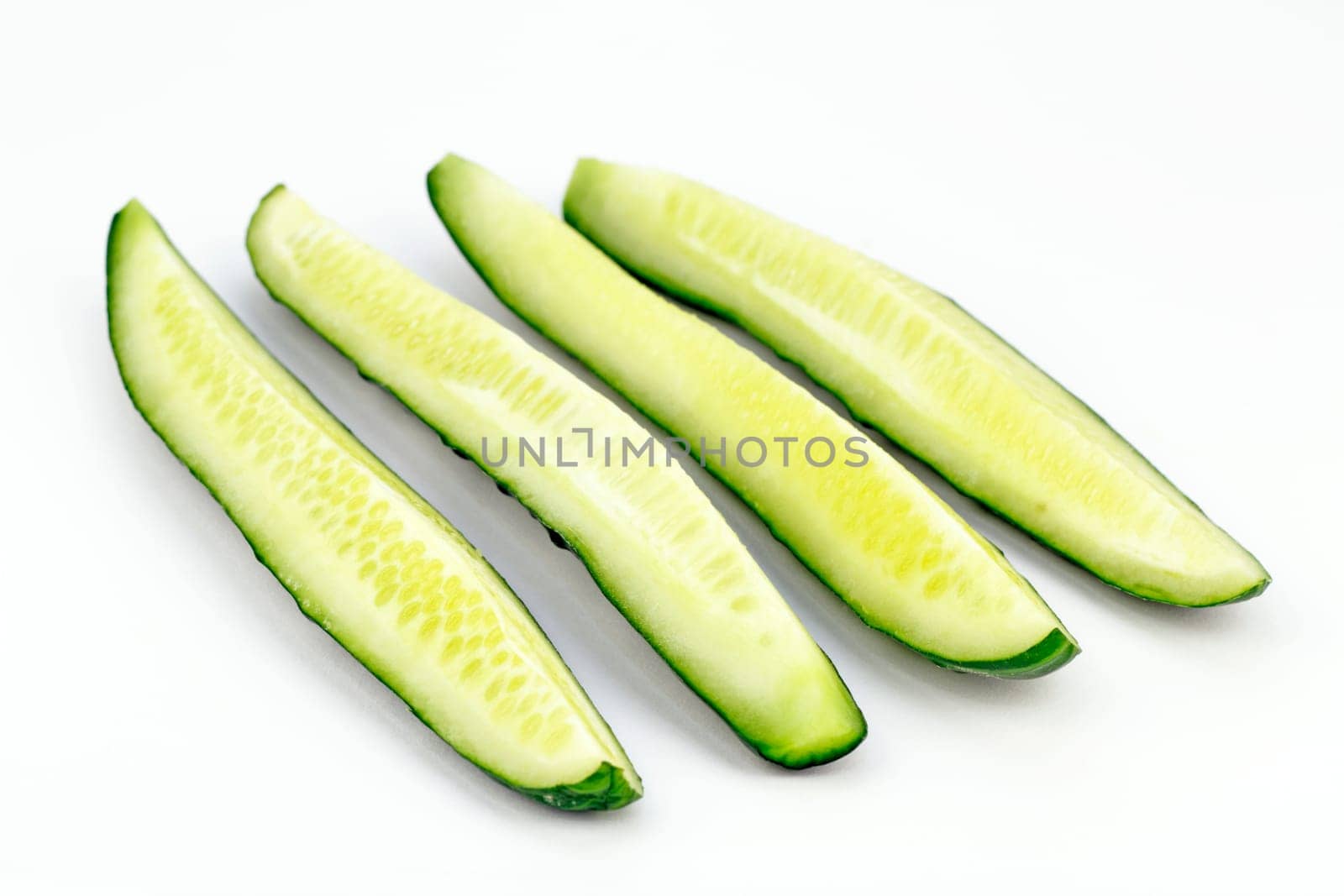 One organic green vegetable sliced in quarters lengthwise.