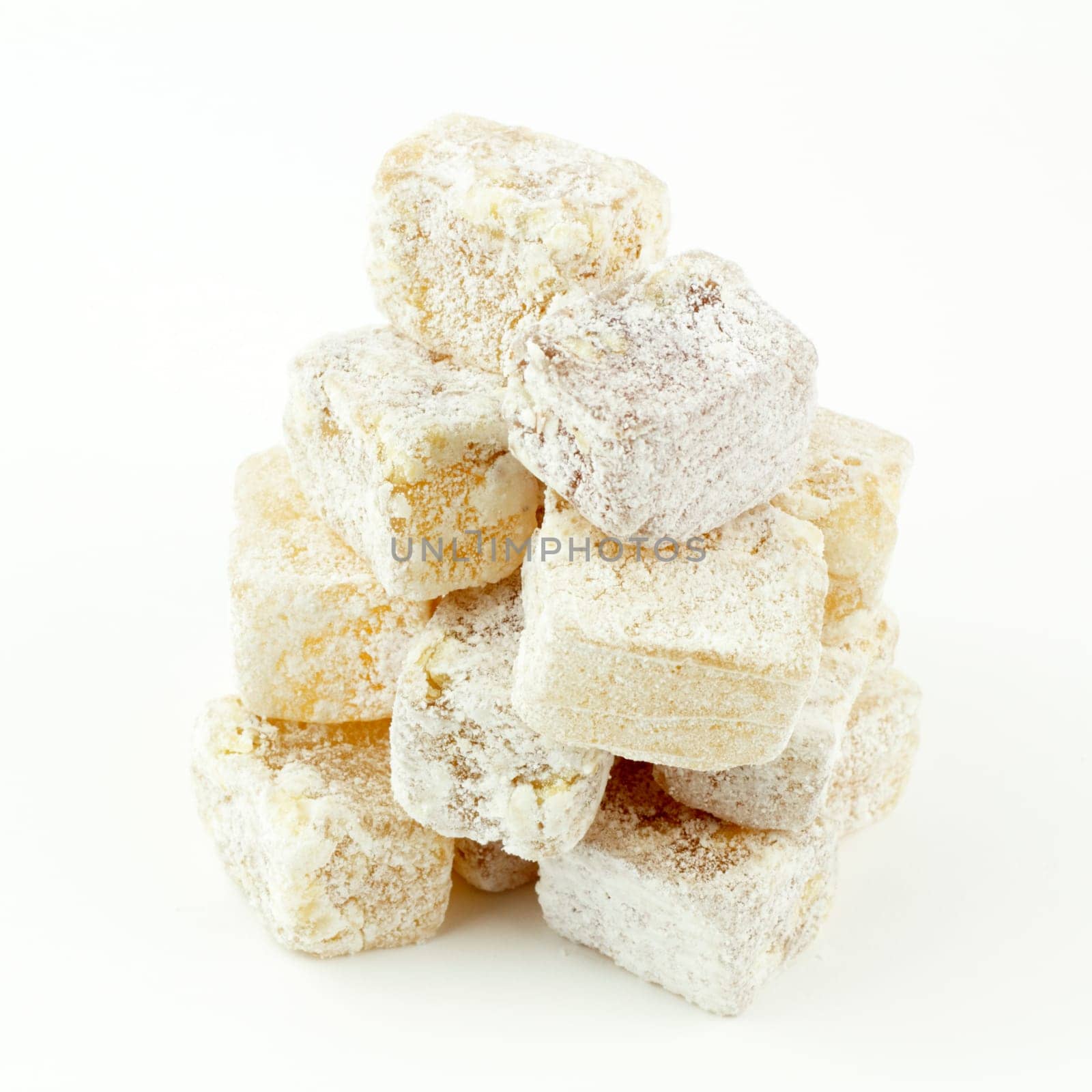 Powdered fruit nut dessert squares stacked in a pyramid like form.