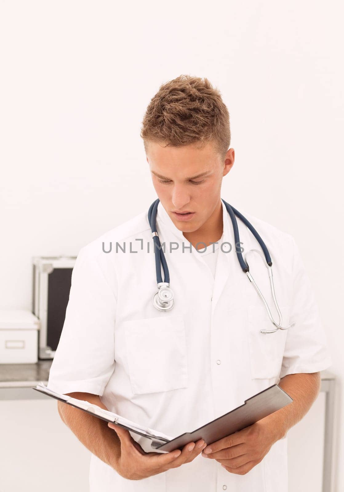 Handsome blond doctor reading results of medical test