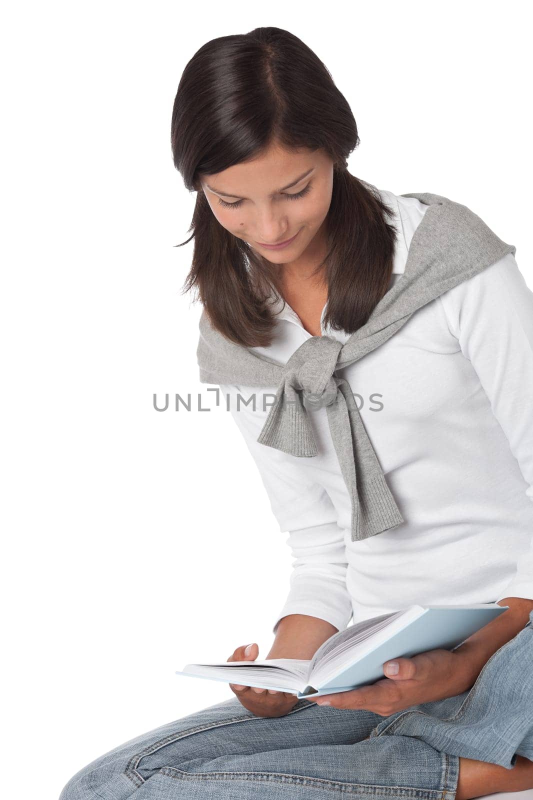 Teenager holding book and reading on white background