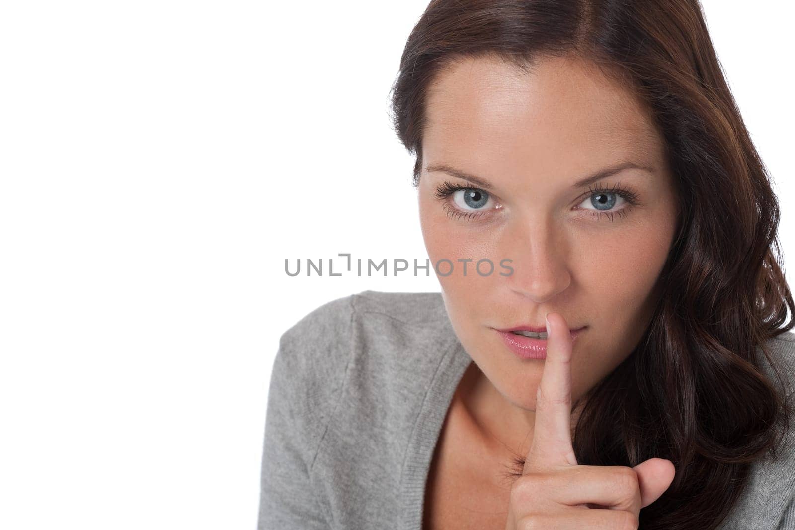 Brown hair woman with with finger on lips on white background