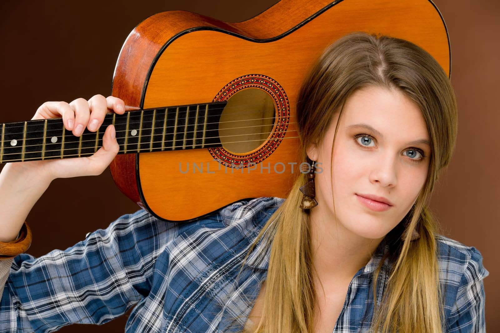 Rock musician - young fashion female model posing with guitar