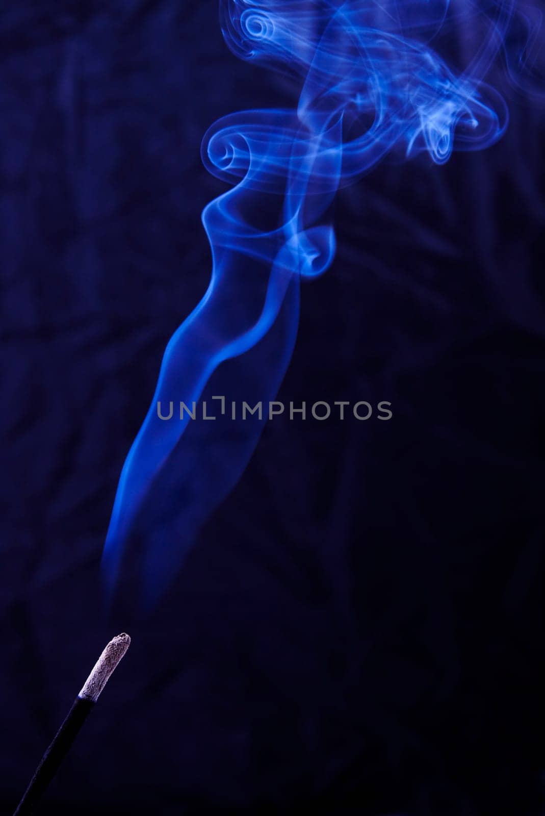 Abstract incense blue smoke against black background