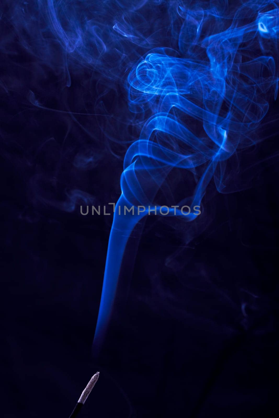 Abstract incense blue smoke against black background