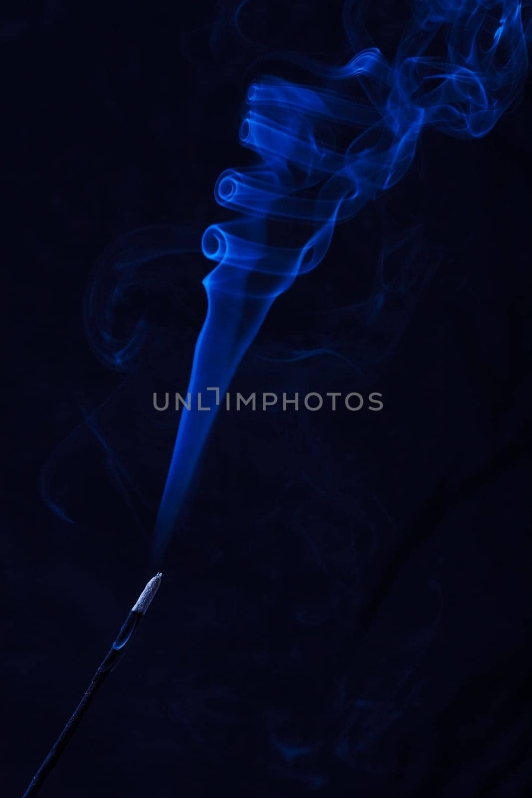 Abstract incense blue smoke against black background