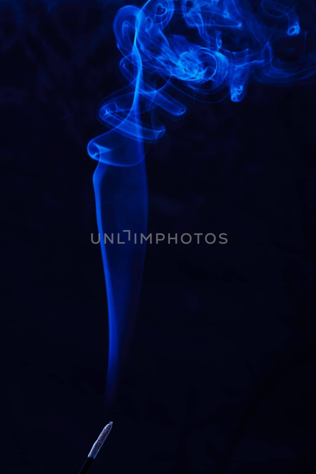 Abstract incense blue smoke against black background