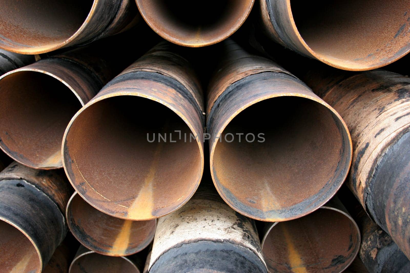 Rusting pile of steel pipes closeup