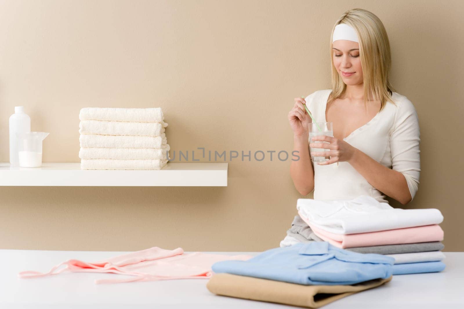 Laundry ironing - woman break with drink after housework