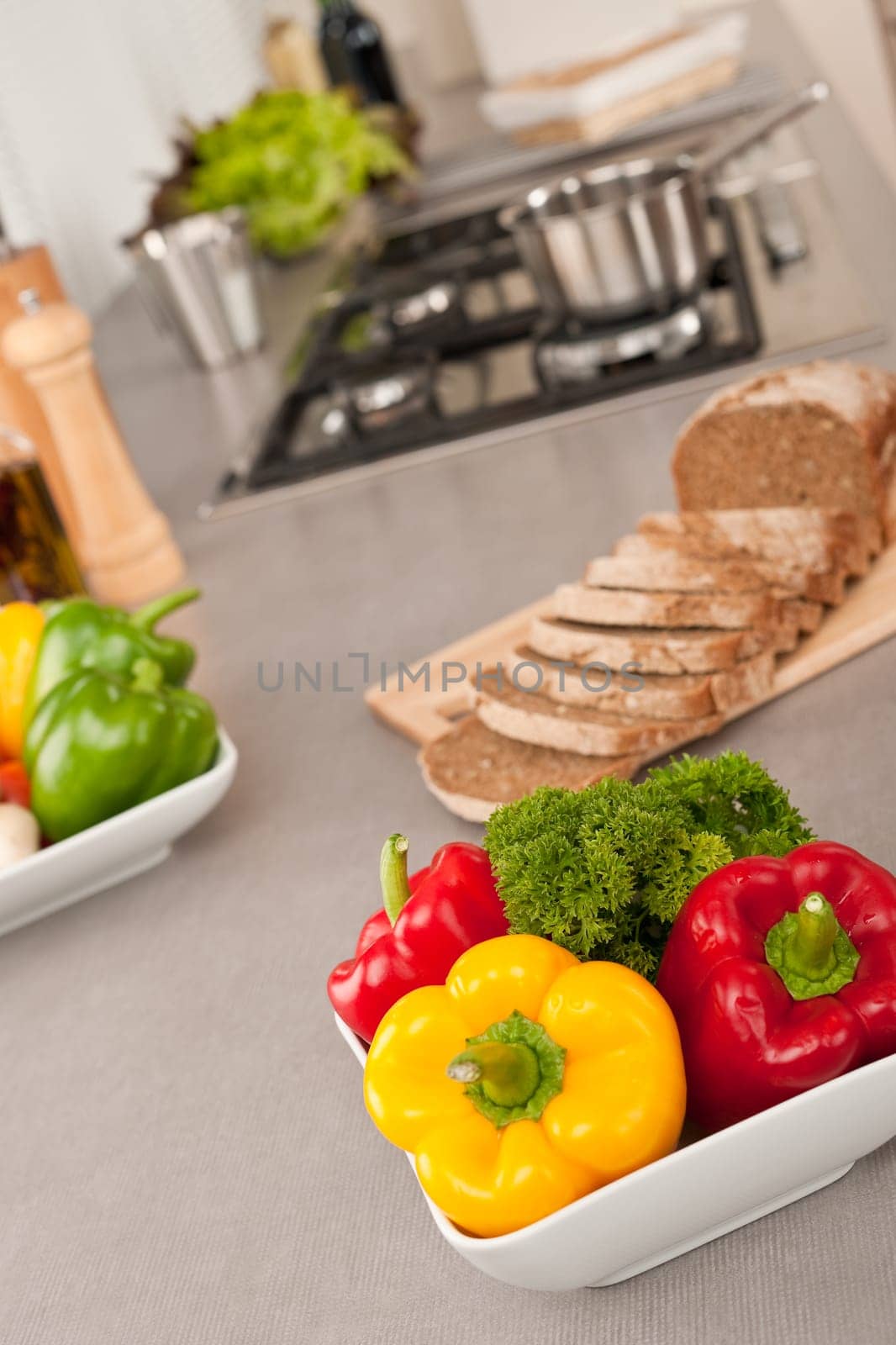 Bowl with vegetable in modern kitchen, focus on pepper