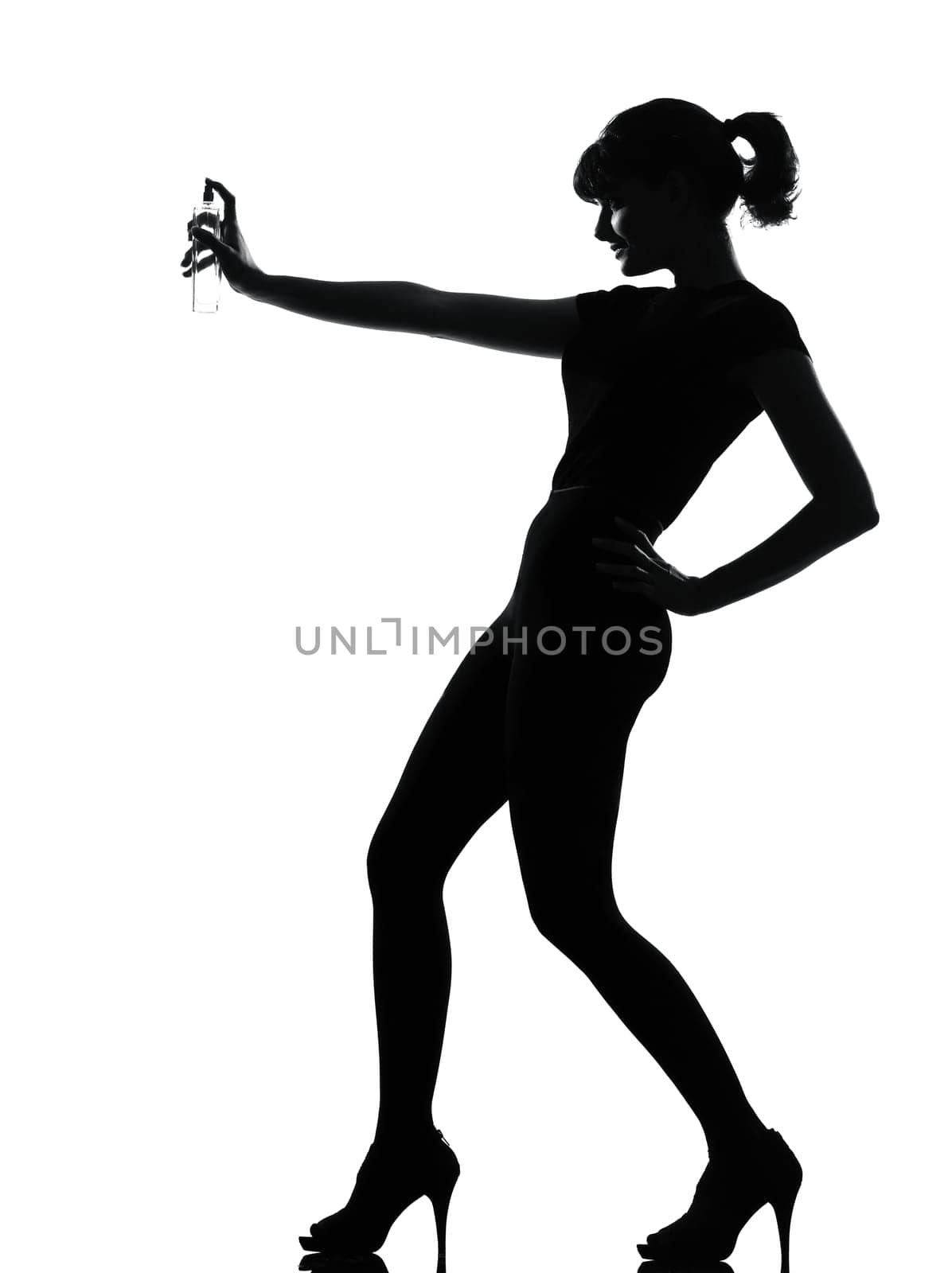 silhouette woman spraying perfume