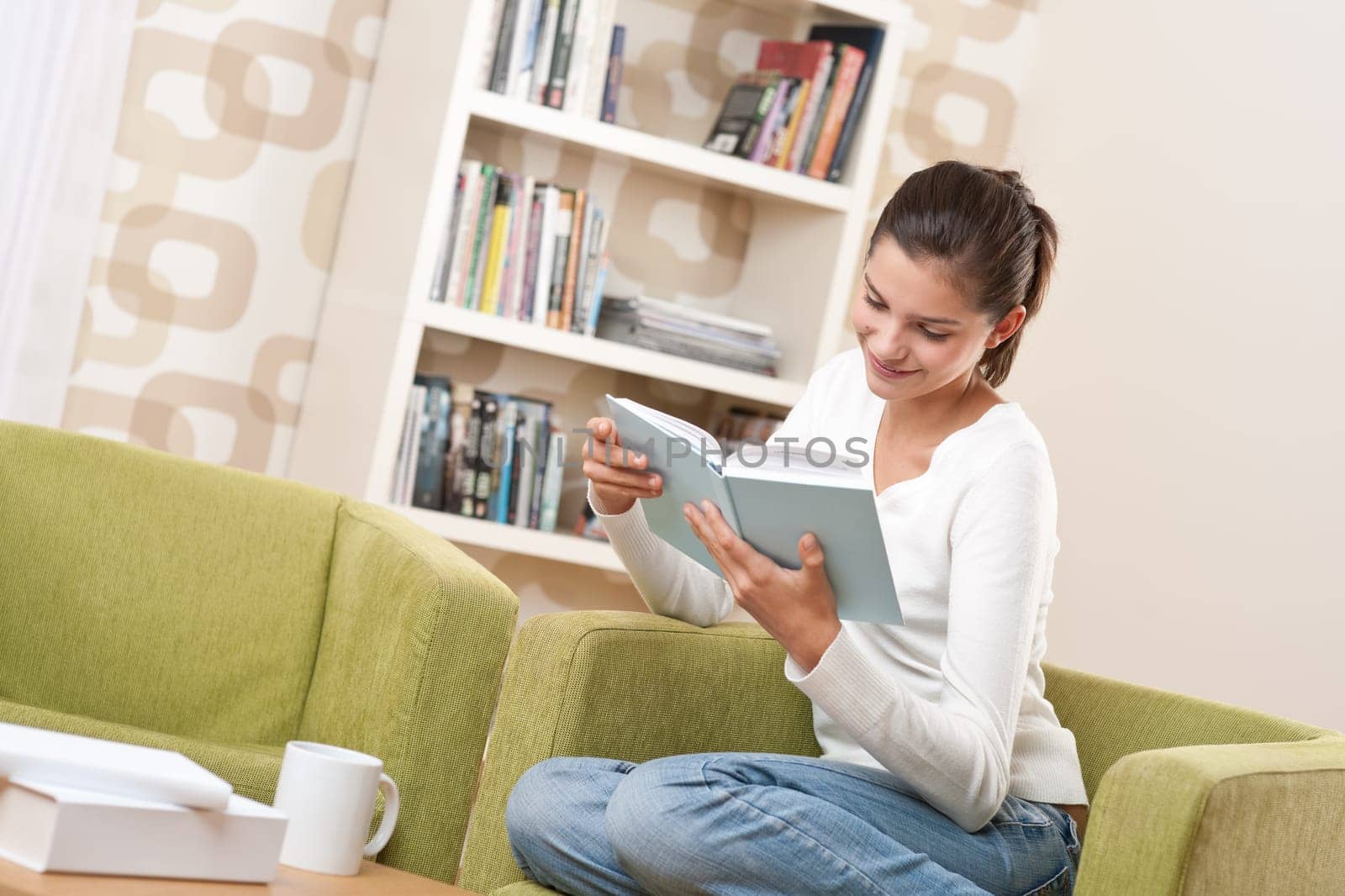 Students - Happy teenager with book sitting on armchair in lounge