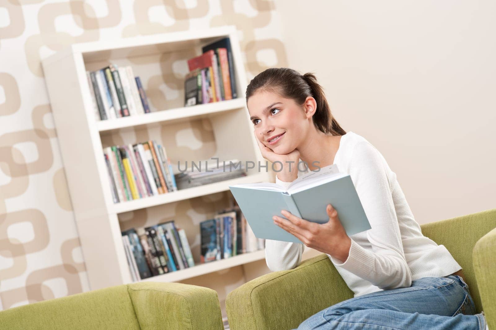 Students - Happy teenager with book sitting on armchair in lounge