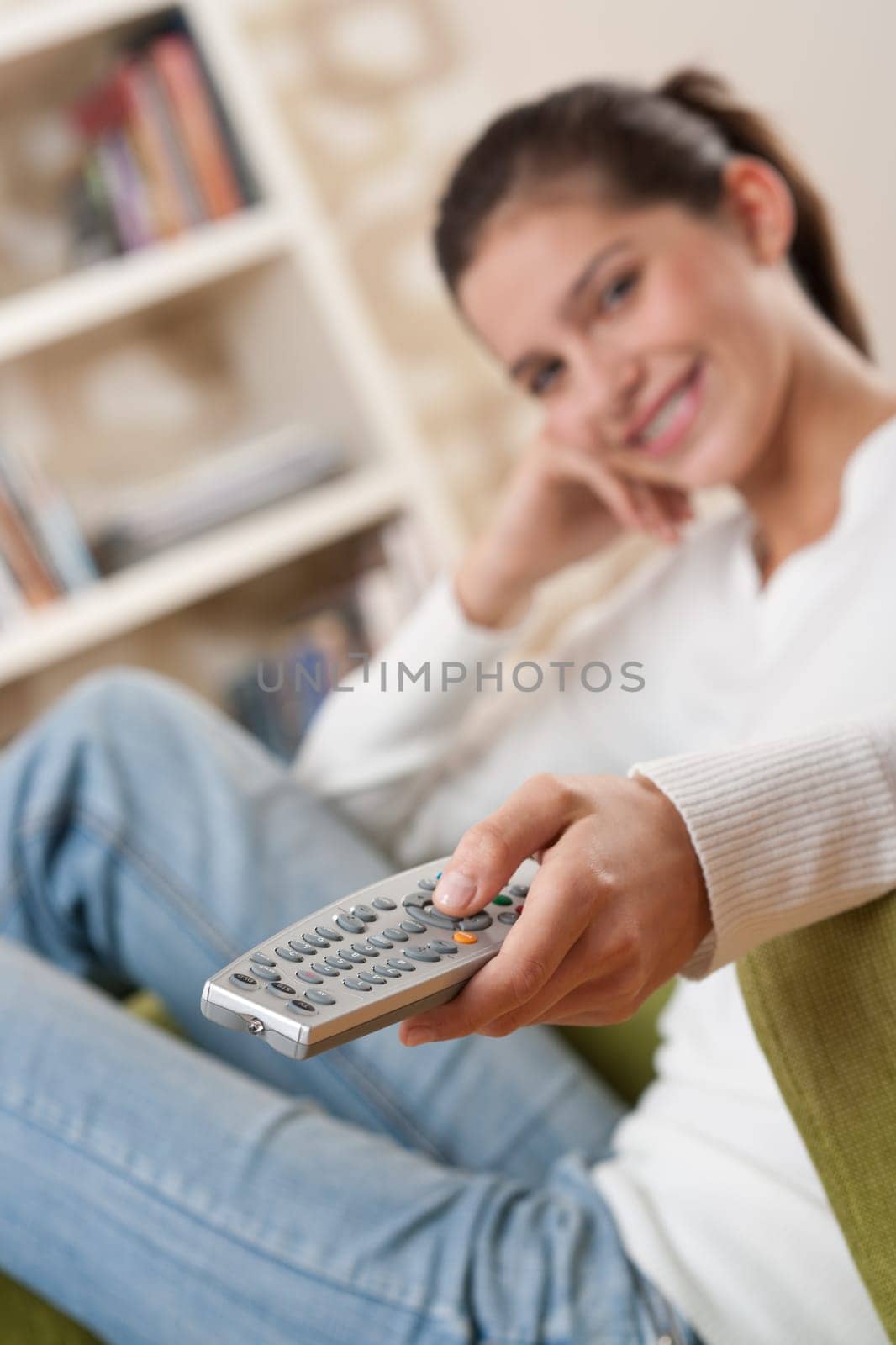 Students - Smiling female teenager watching television in living room