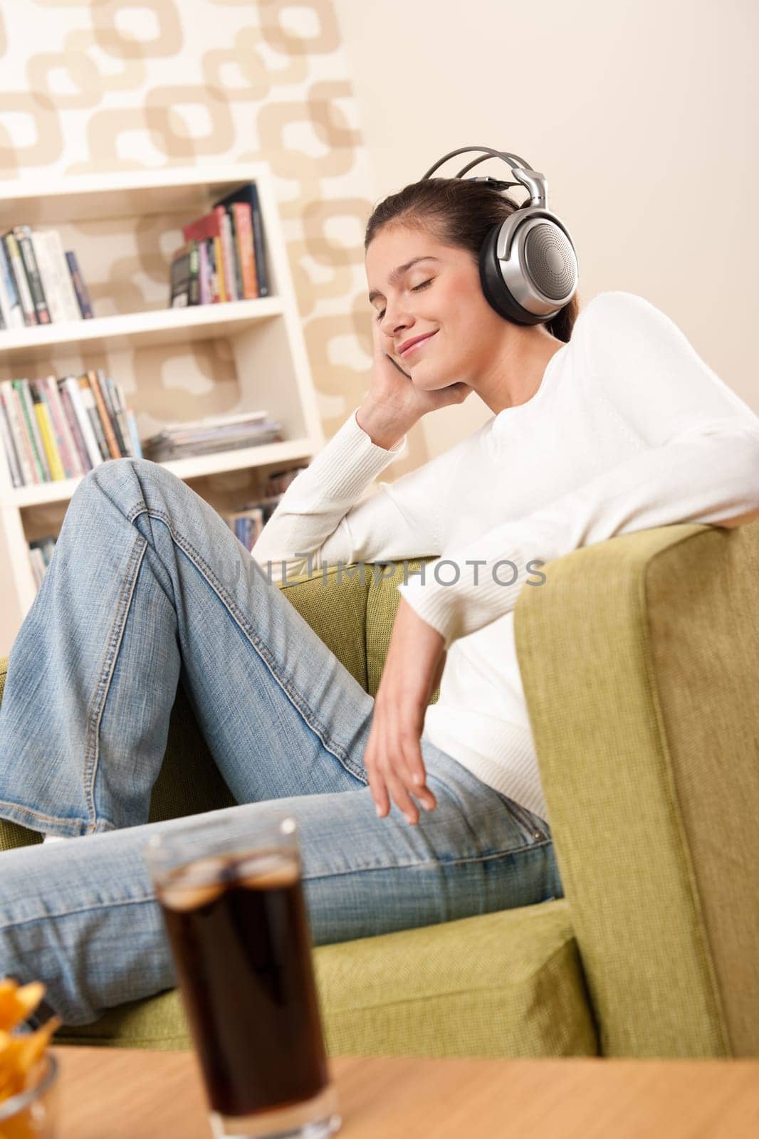 Students - Happy female teenager with headphones listening to music in modern lounge