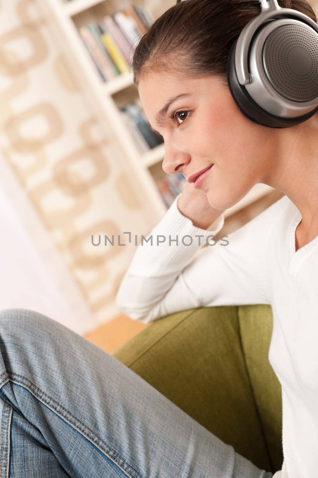 Students - Happy female teenager with headphones listening to music in modern lounge