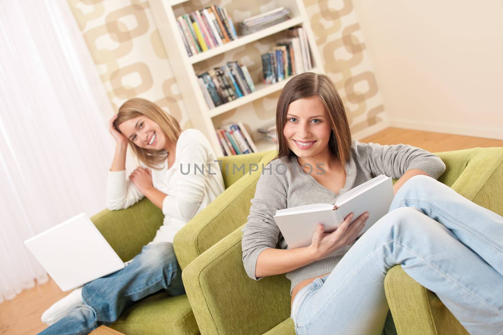 Students - Two female teenager studying with laptop and book in modern living room