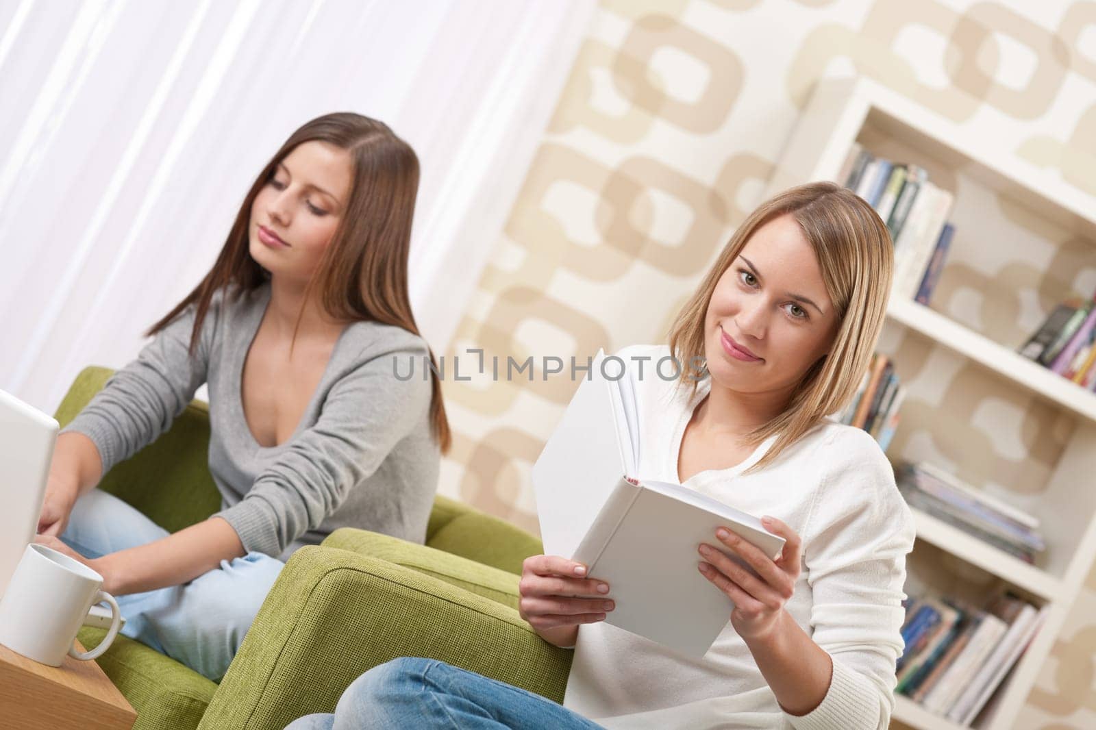 Students - Two female teenager studying sitting on green armchair