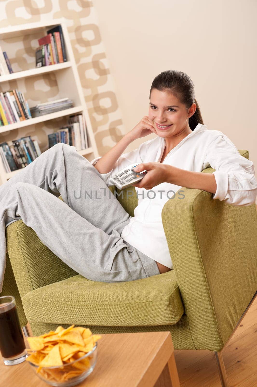 Students - Happy female teenager with potato chips in modern living room