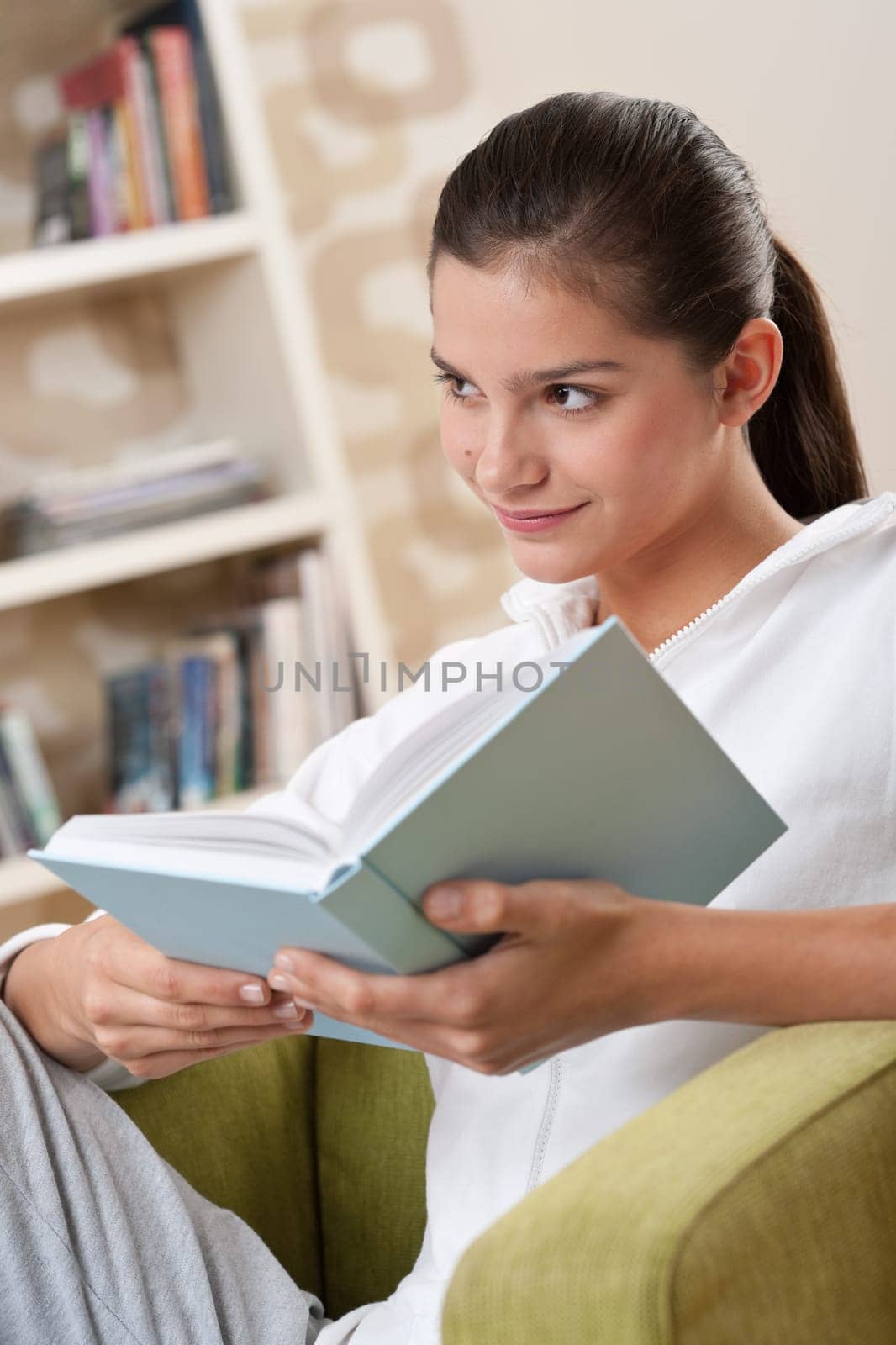 Students - Female teenager reading book in modern living room