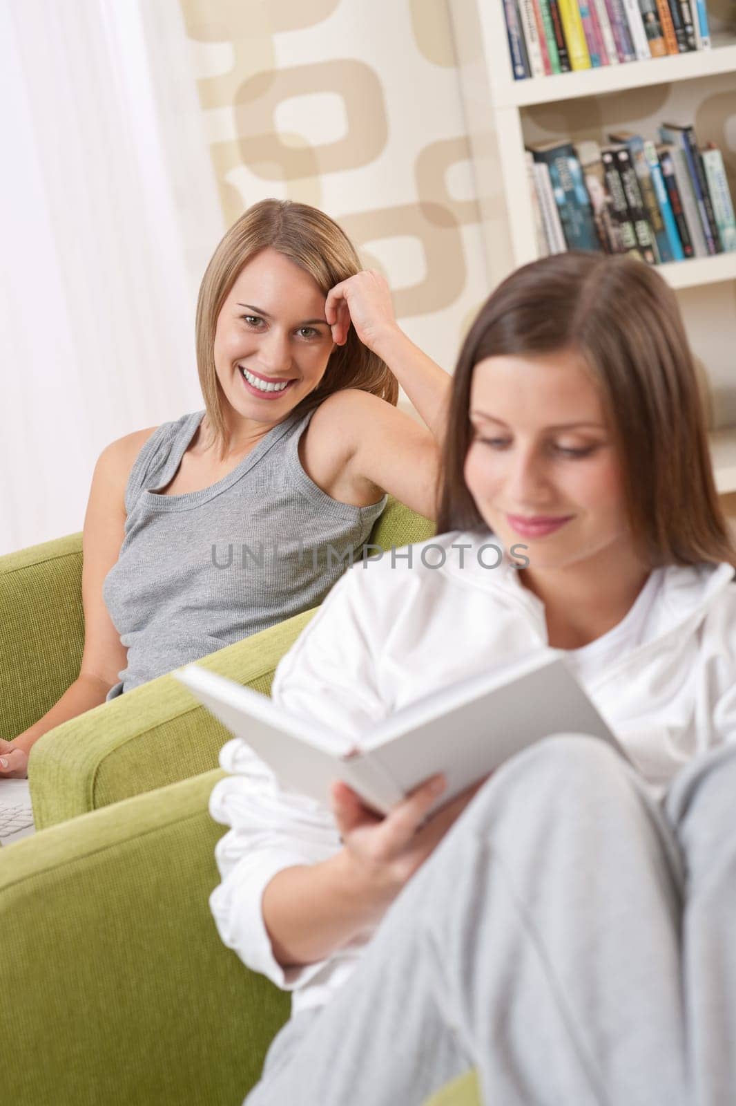 Students - Two female students studying in lounge, reading book