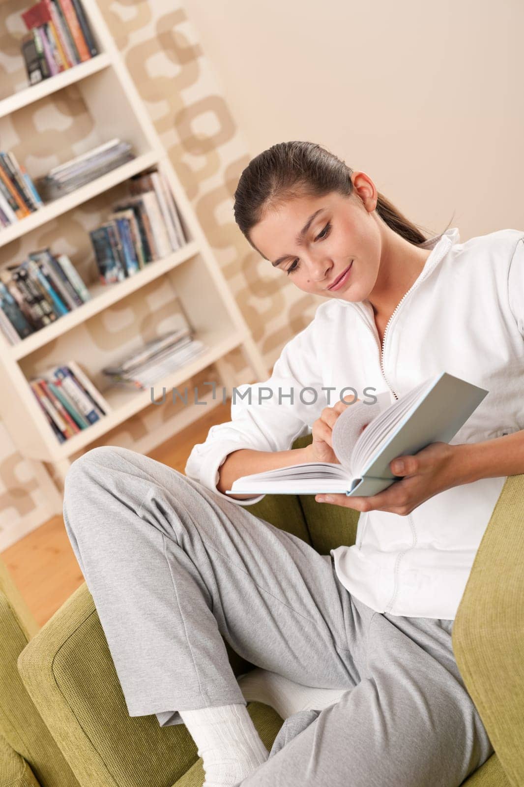 Students - Female teenager reading book in modern living room
