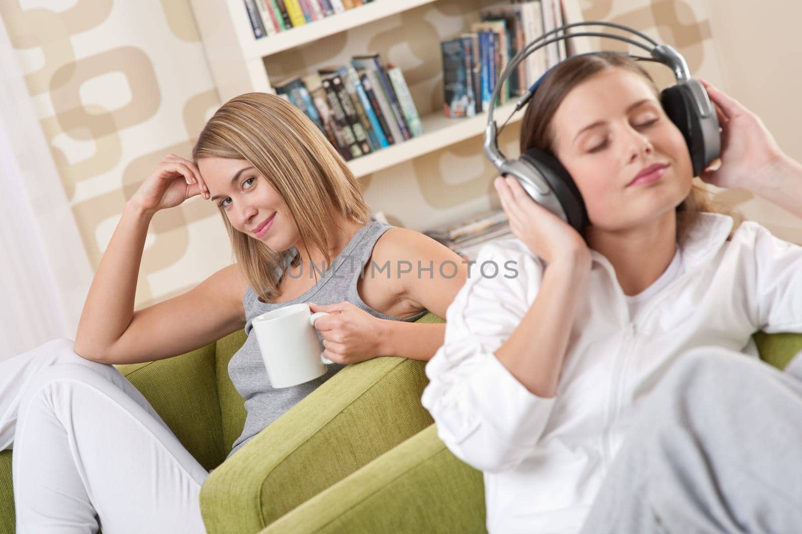 Students - Two female teenager relaxing in lounge having coffee and listening to music