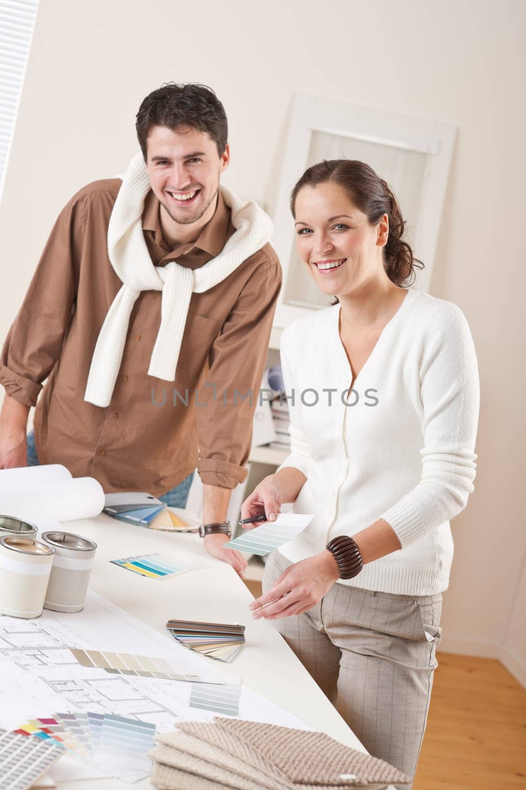 Two interior designer working at office with color swatch and can of paint