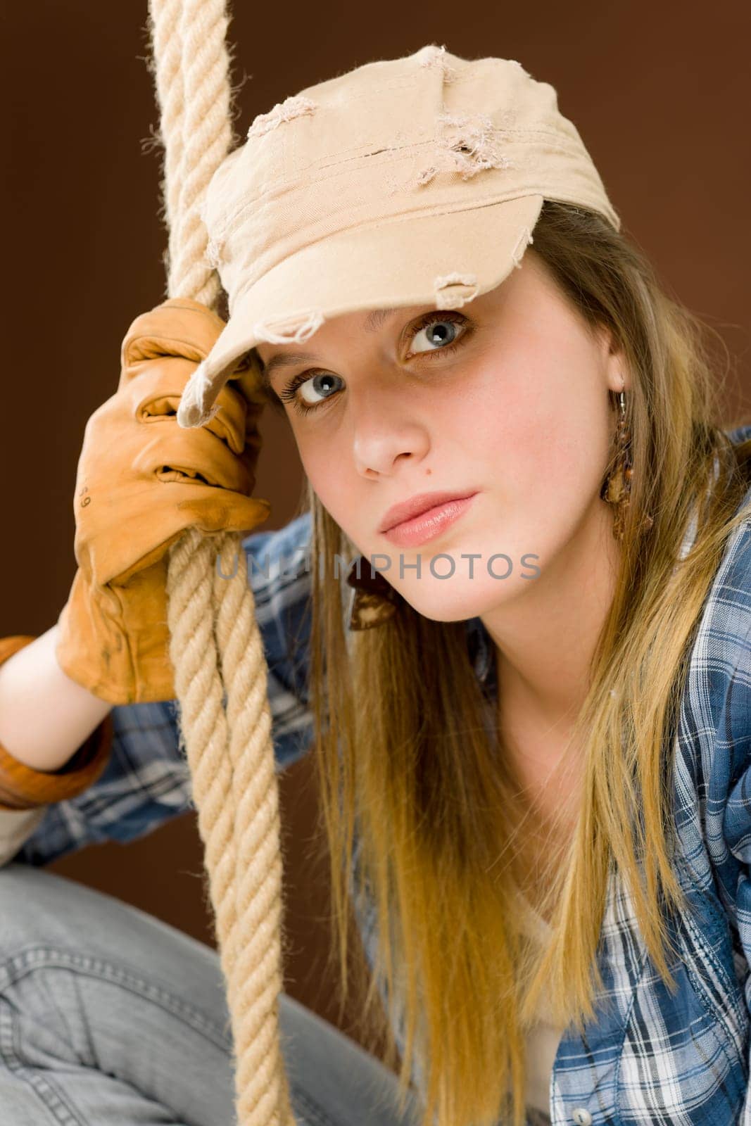 Fashion model - young woman country style posing with rope