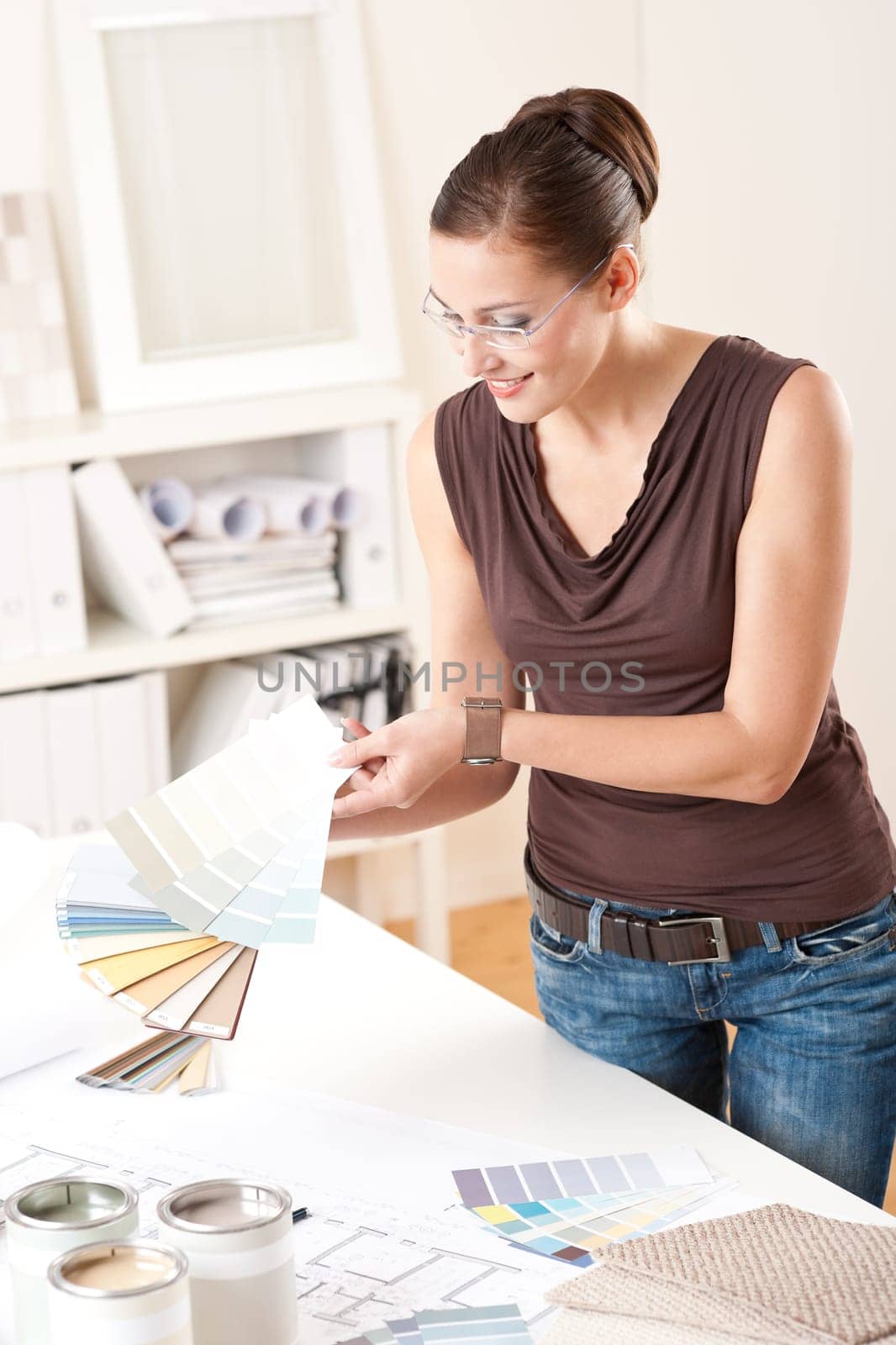 Young female designer working at office with color swatches