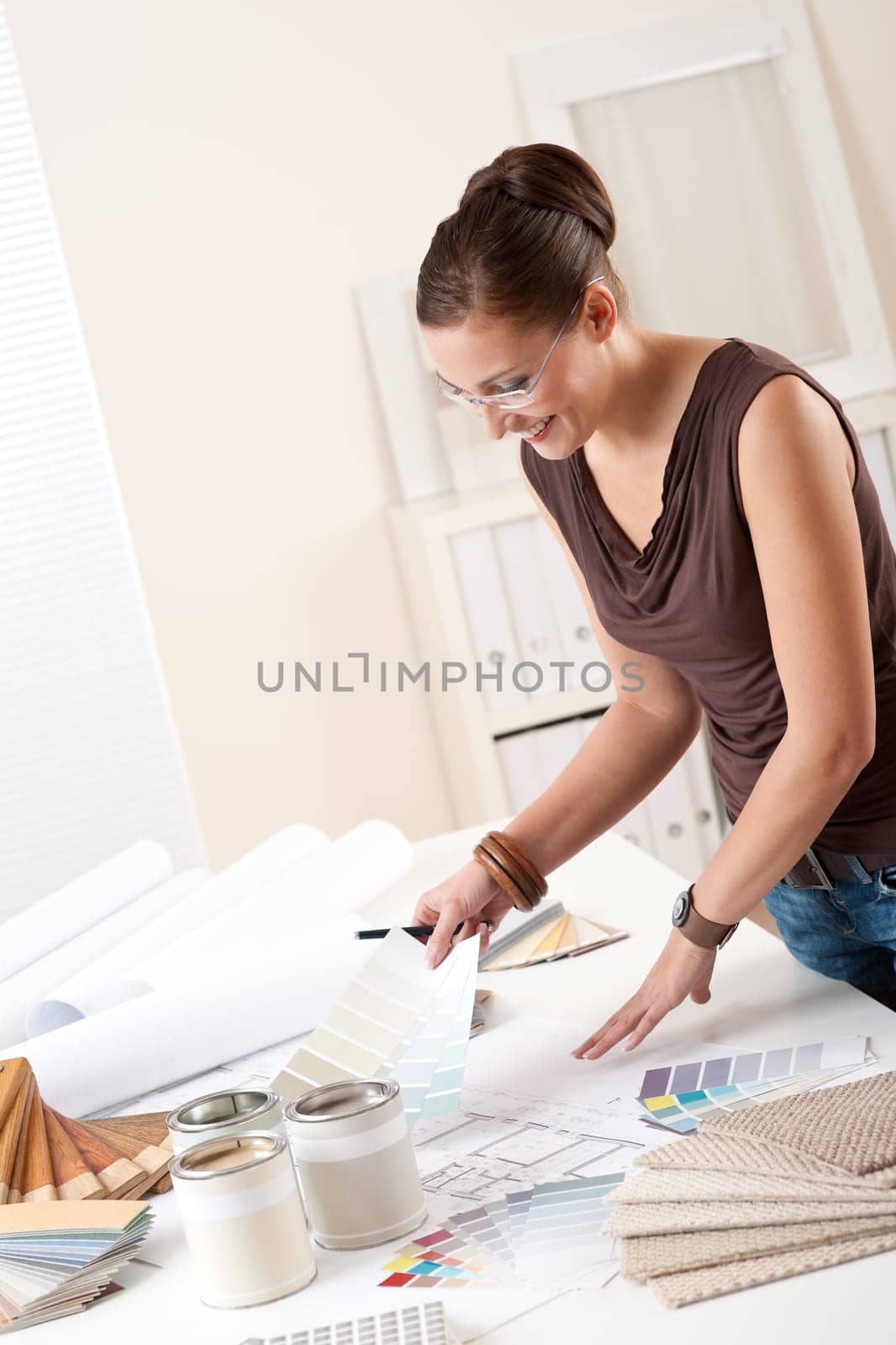 Young female designer working at office with color swatches