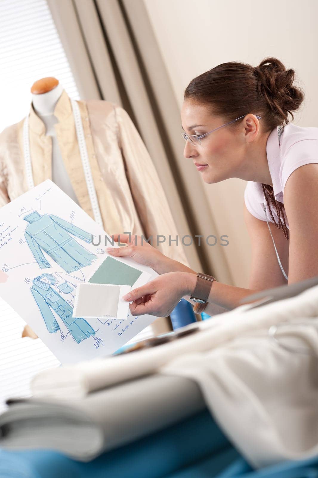 Professional tailor holding fashion sketch working at studio