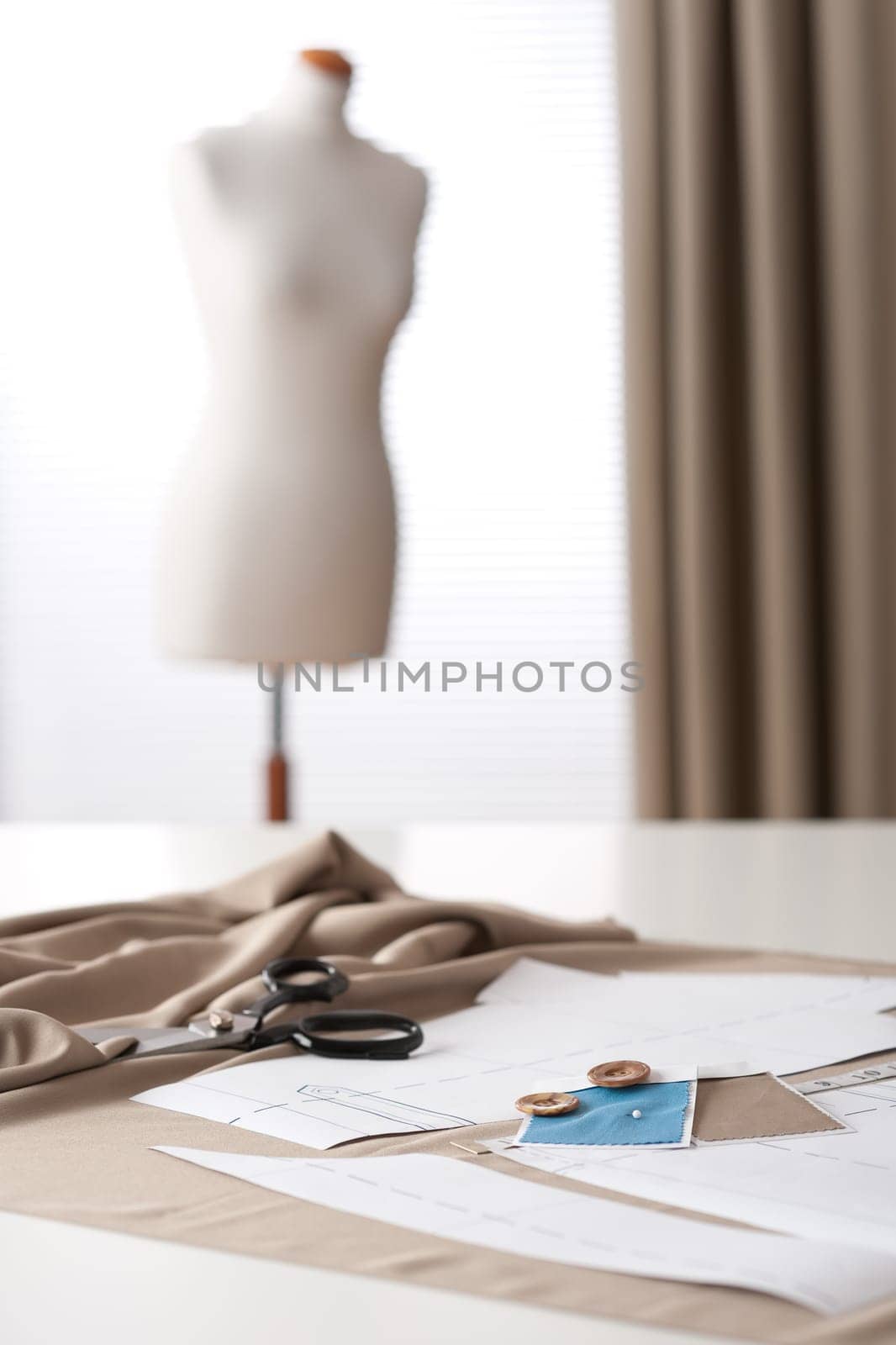 Fashion designer studio with professional equipment, sketches, mannequin, cloth