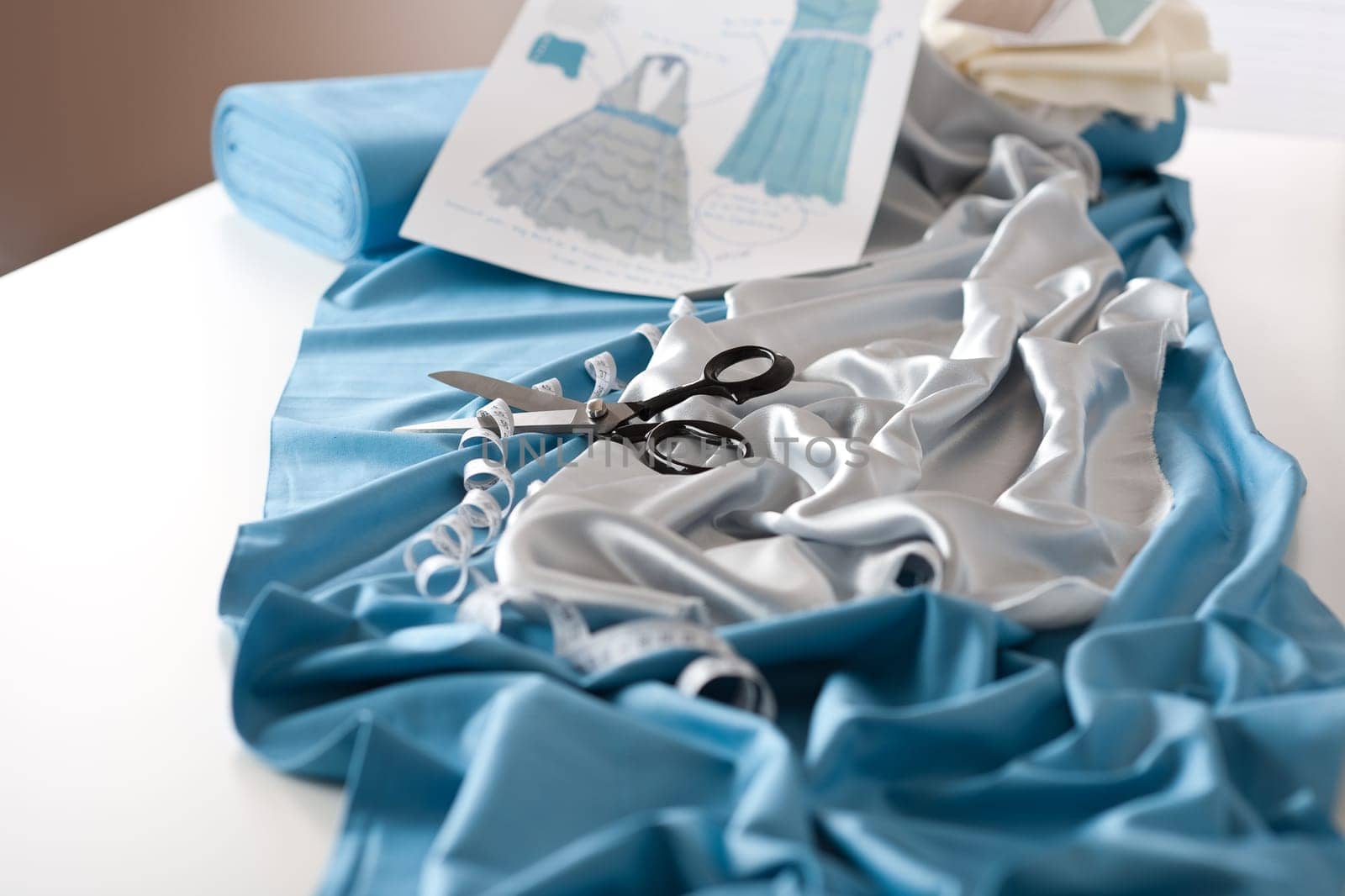 Fashion designer studio with professional equipment on desk, cloth, scissors