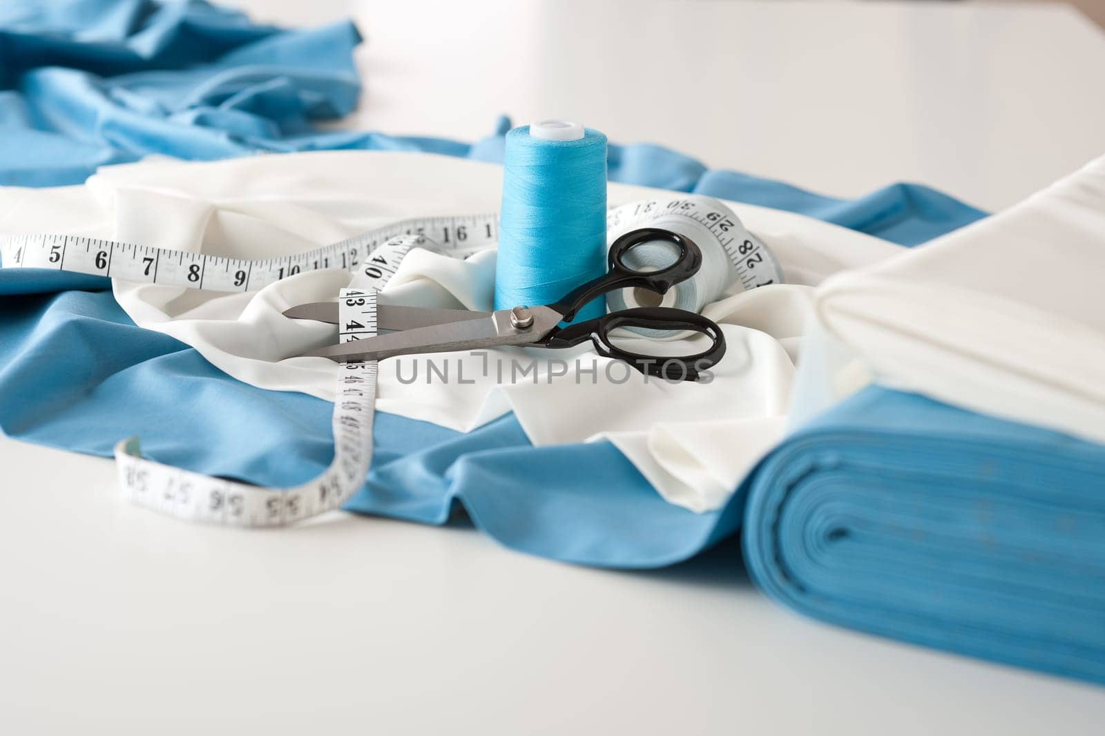 Fashion designer studio with professional equipment on desk, cloth, scissors