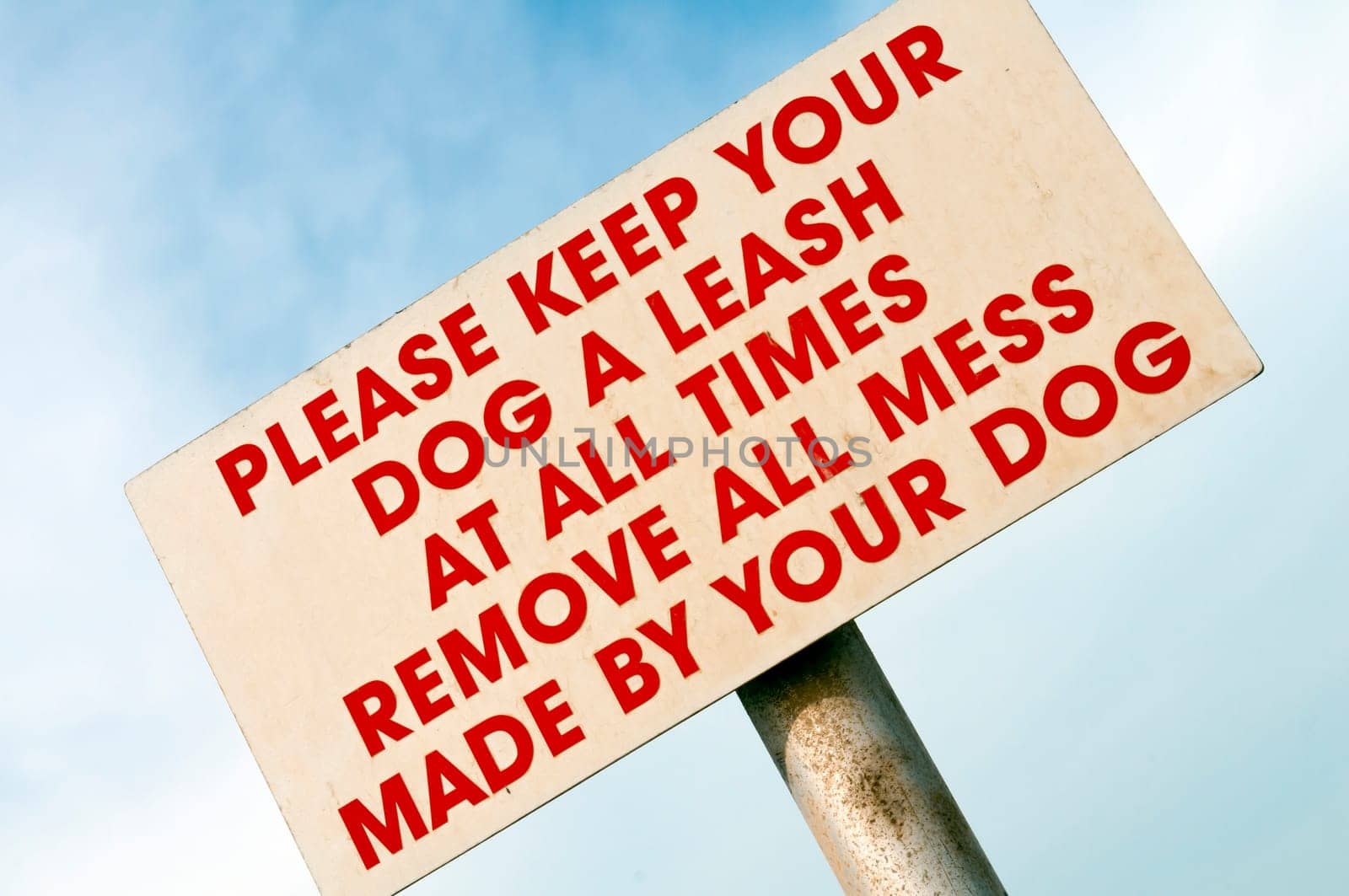 Keep your dog a leash at all times sign against the sky