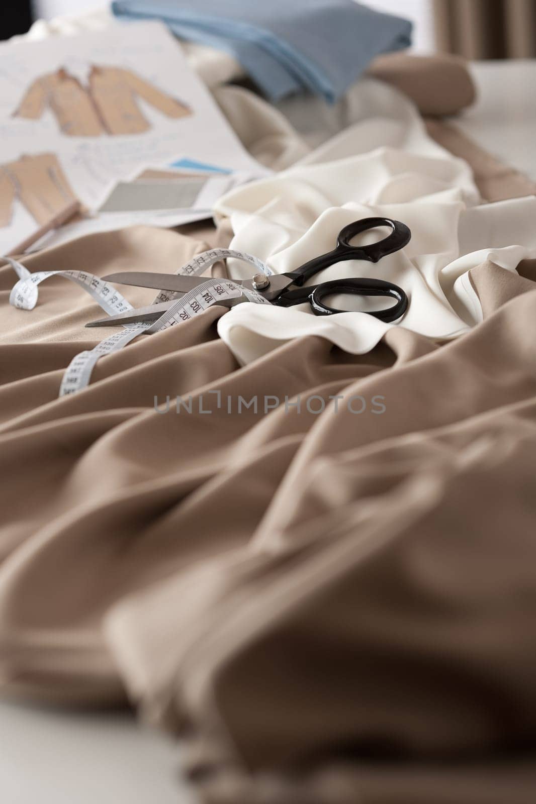Fashion designer studio with professional equipment on desk, cloth, scissors