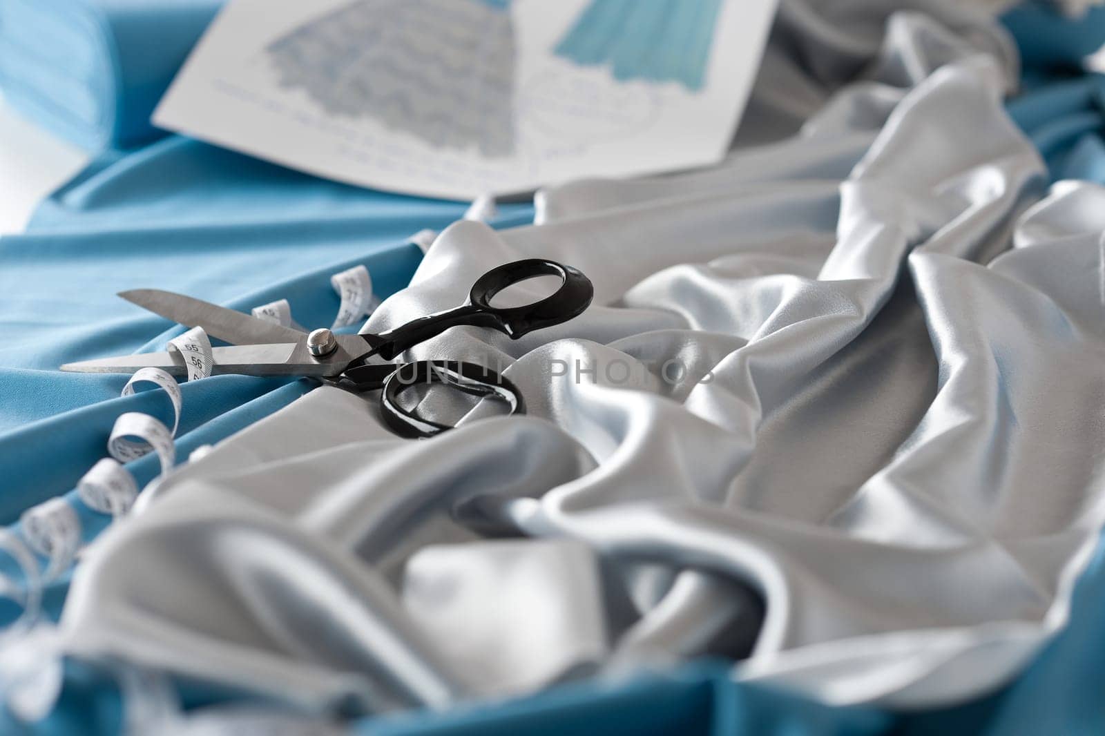 Fashion designer studio with professional equipment on desk, cloth, scissors