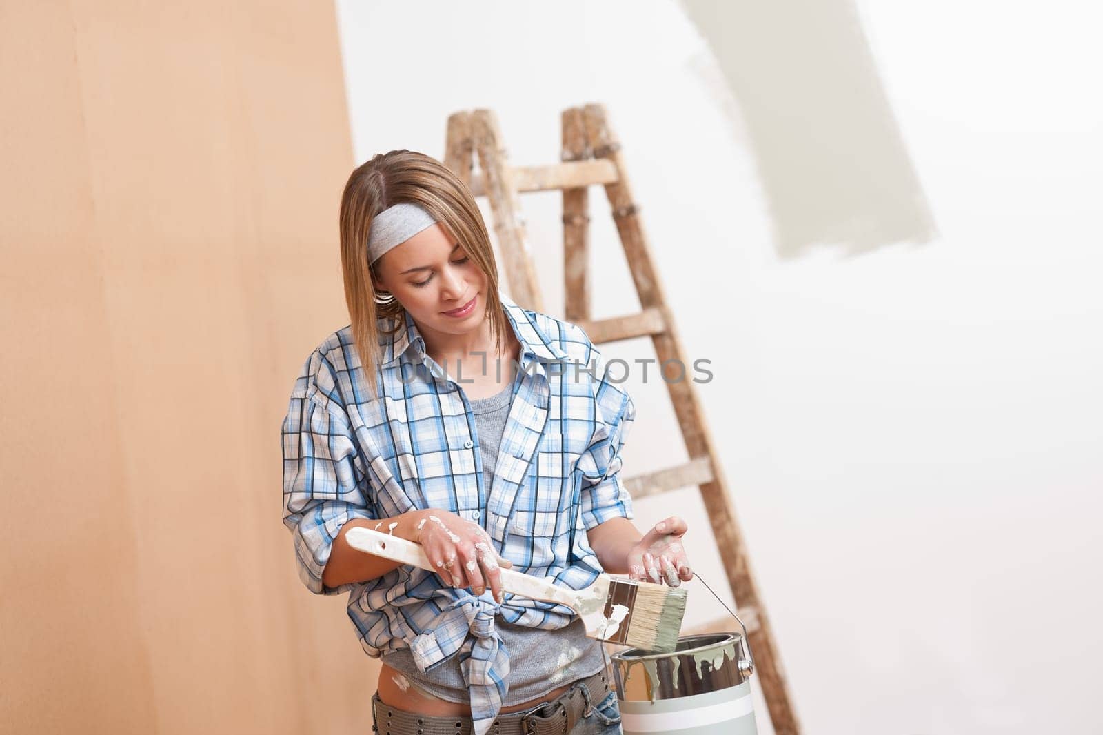 Home improvement: Smiling woman with paint and brush