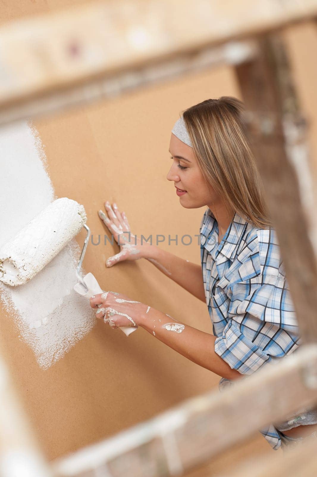Home improvement: Woman painting wall with paint roller